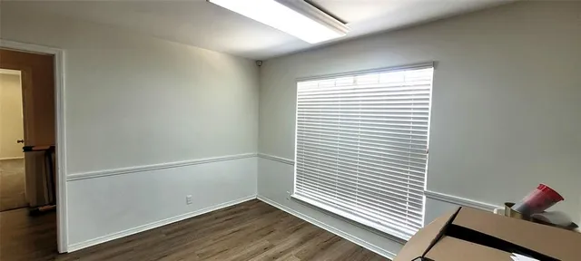 a view of a room with wooden floor and a window