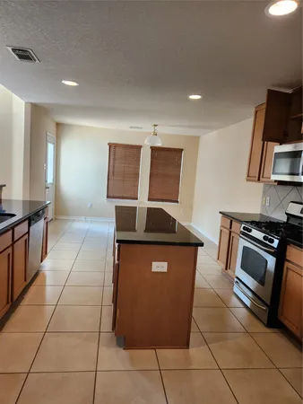 a kitchen with stainless steel appliances granite countertop a sink and a stove