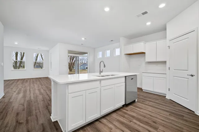 a kitchen with white cabinets and sink