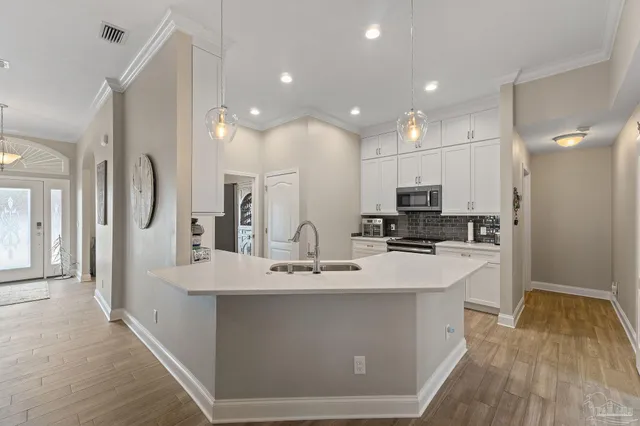 a kitchen with white cabinets and stainless steel appliances