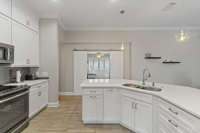 a kitchen with white cabinets and appliances