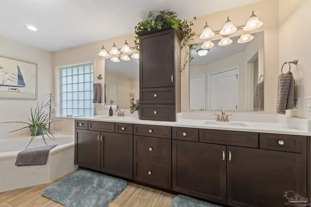 a spacious bathroom with a double vanity sink a large mirror and a bathtub