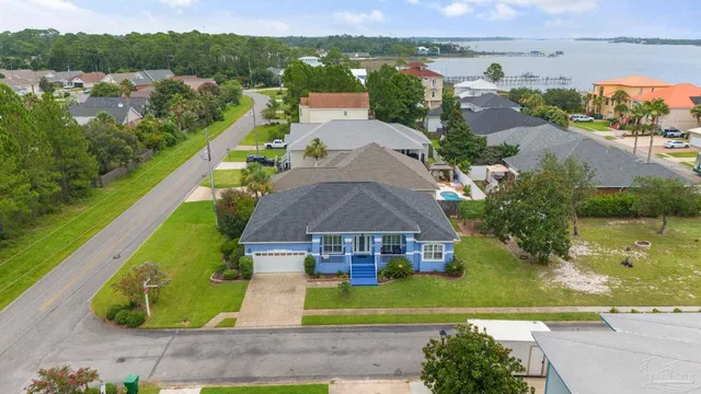 an aerial view of residential houses with outdoor space and lake view