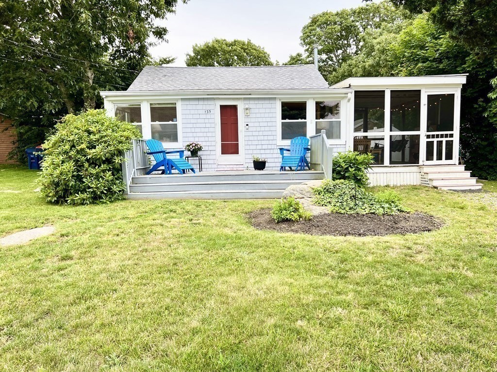 a front view of a house with porch and garden