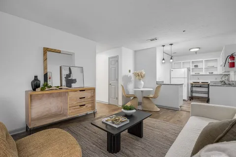 a living room with furniture and a dining table with kitchen view