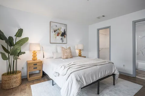 a bedroom with a bed and a potted plant