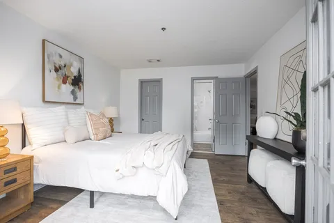 a bedroom with a bed and wooden floor