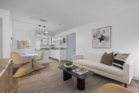 a living room with furniture and view of kitchen