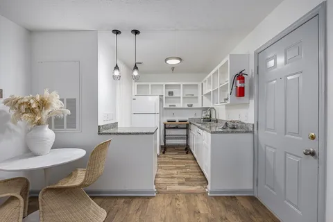 a kitchen with kitchen island a stove a table and chairs in it
