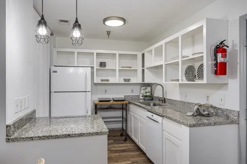 a kitchen with granite countertop a sink stainless steel appliances and cabinets