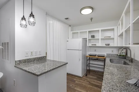 a kitchen with stainless steel appliances granite countertop a sink and a refrigerator