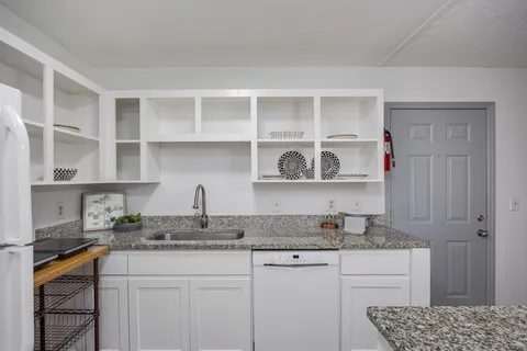 a kitchen with stainless steel appliances granite countertop a sink stove and cabinets