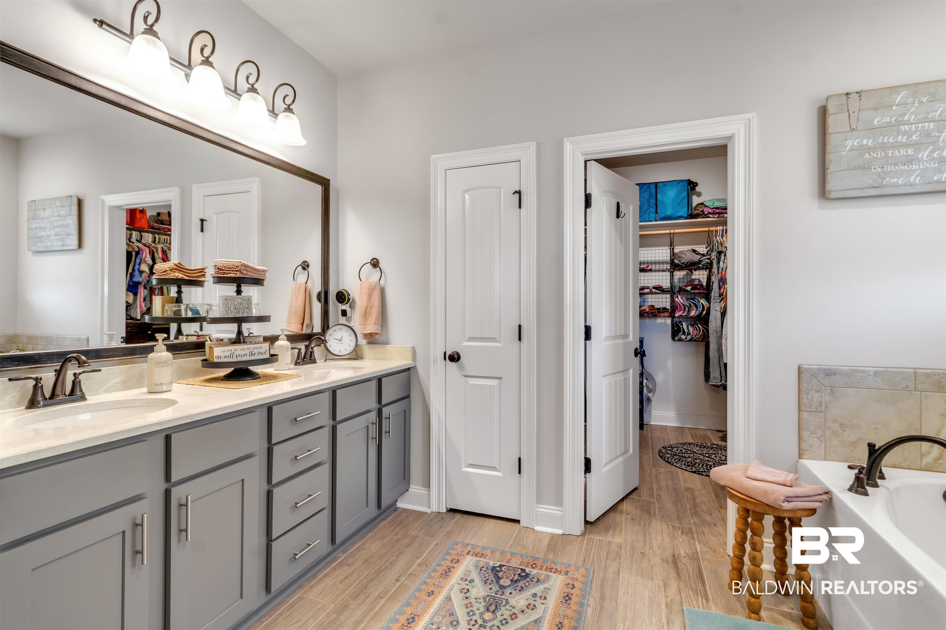 22531 Putter Lane Foley, AL 36535 - Photo 23 of 43 Full bathroom featuring a walk in closet, double vanity, light wood-style floors, and a bath