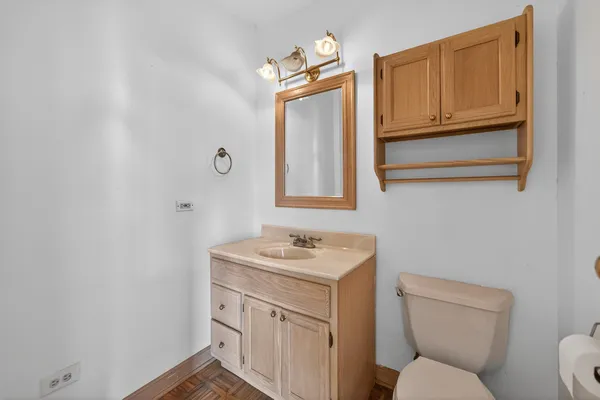 a bathroom with a toilet sink vanity and mirror