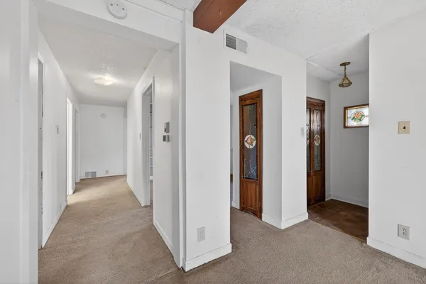 a view of a hallway with closet and bathroom