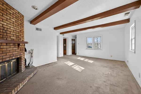 a view of a livingroom with an empty space and a fireplace