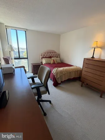 a bedroom with a bed gym equipment and view of living room