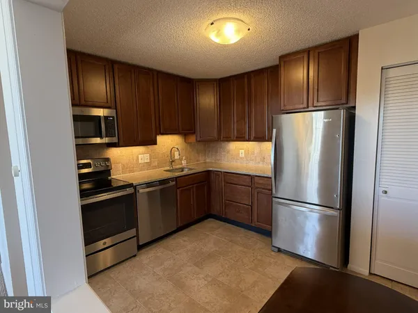 a kitchen with granite countertop stainless steel appliances and refrigerator