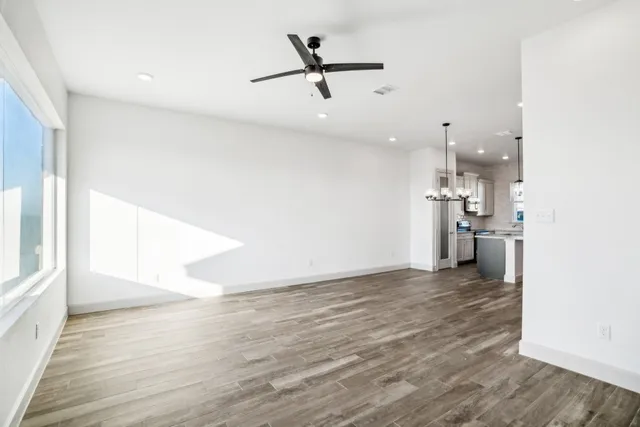 a view of empty room with wooden floor and a ceiling fan