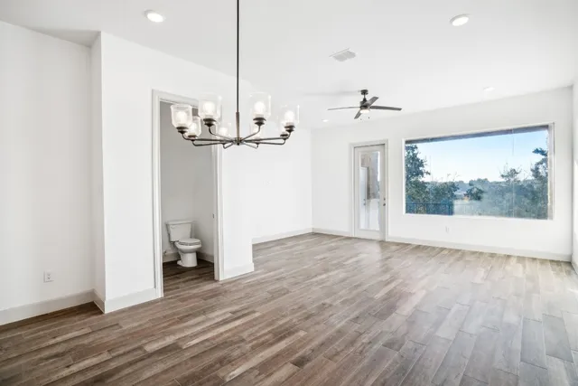 a view of a room with wooden floor and a ceiling fan