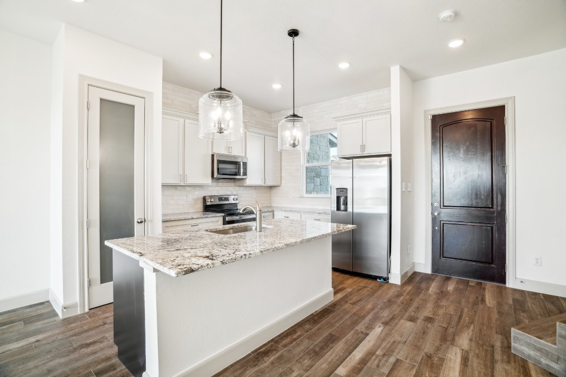 289 Star Grass Spring Branch, TX 78070 - Photo 16 of 39 a kitchen with a refrigerator a sink and a wooden floor