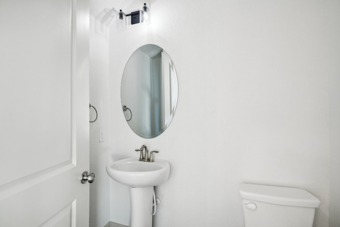 289 Star Grass Spring Branch, TX 78070 - Photo 20 of 39 a bathroom with a toilet sink and mirror