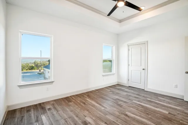 an empty room with wooden floor and window