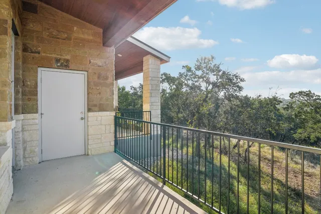 a view of a balcony with wooden floor and fence