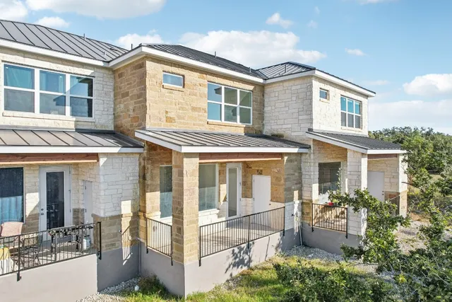 a front view of a house with plants
