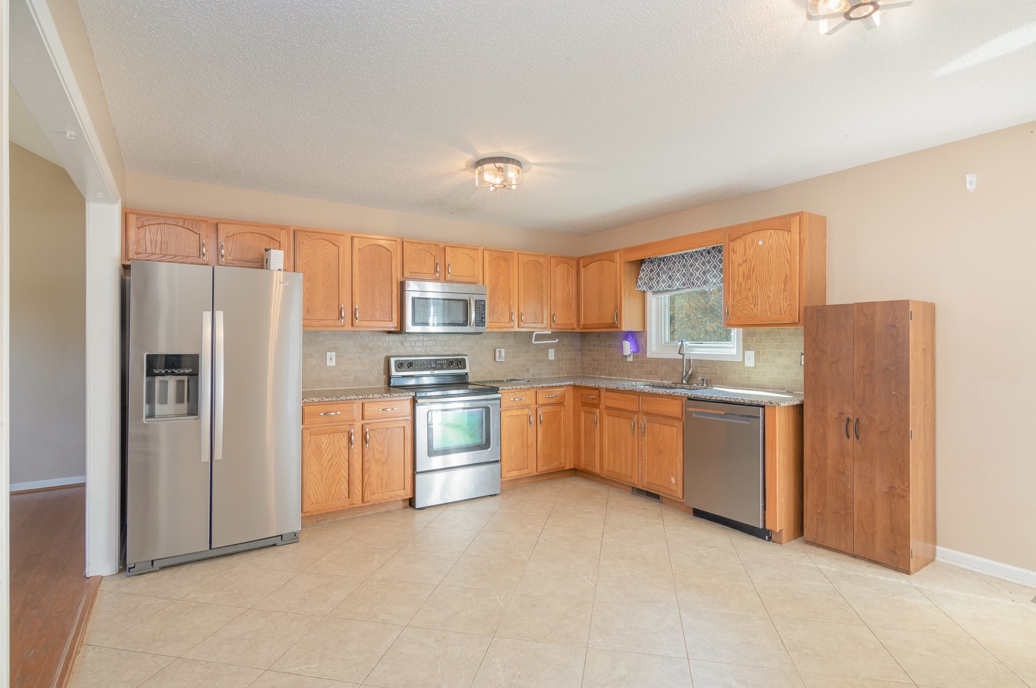 3289 Backridge Road Woodlawn, TN 37191 - Photo 12 of 30 a large kitchen with granite countertop a refrigerator stove top oven and sink