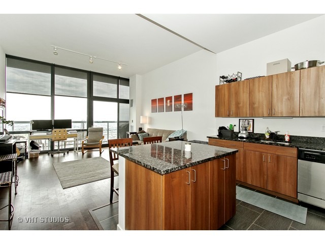 235 West Van Buren Street, Unit 4606 Chicago, IL 60607 - Photo 7 of 22 a kitchen with granite countertop a stove a sink a dining table and chairs