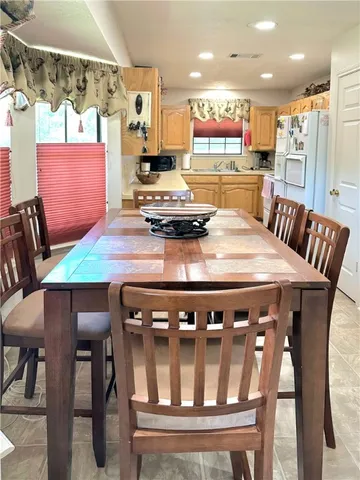 a kitchen with stainless steel appliances kitchen island granite countertop a dining table chairs and view living room