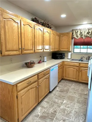 a kitchen with a sink window and cabinets