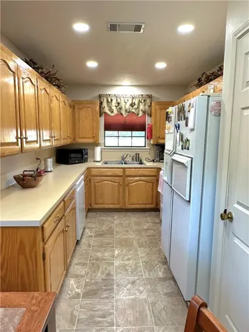 a kitchen with a refrigerator a sink and cabinets