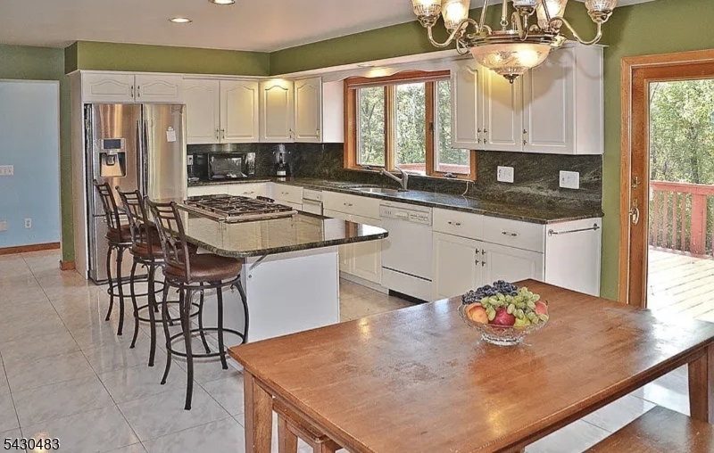 77 Taylortown Road Montville, NJ 07045 - Photo 11 of 11 a kitchen with stainless steel appliances granite countertop a stove a sink a microwave a dining table and chairs