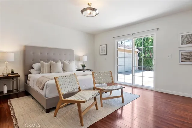 a spacious bedroom with a bed and wooden floor