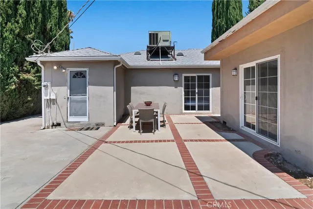 a view of a patio with a table and chairs and potted plants