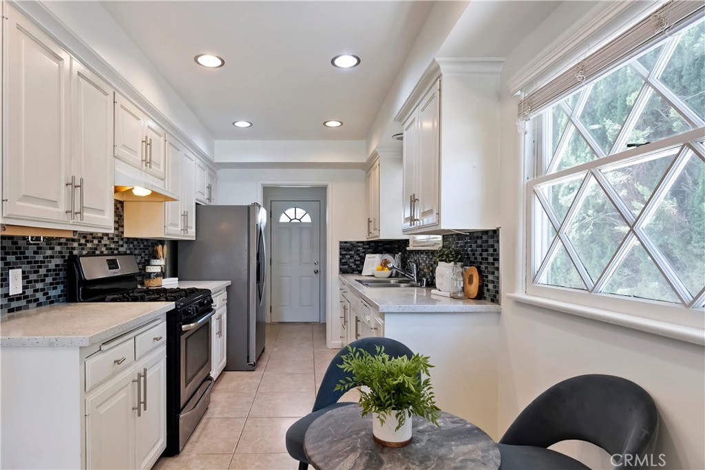 16828 Margate Street Encino, CA 91436 - Photo 7 of 21 a kitchen with a sink stainless steel appliances and cabinets