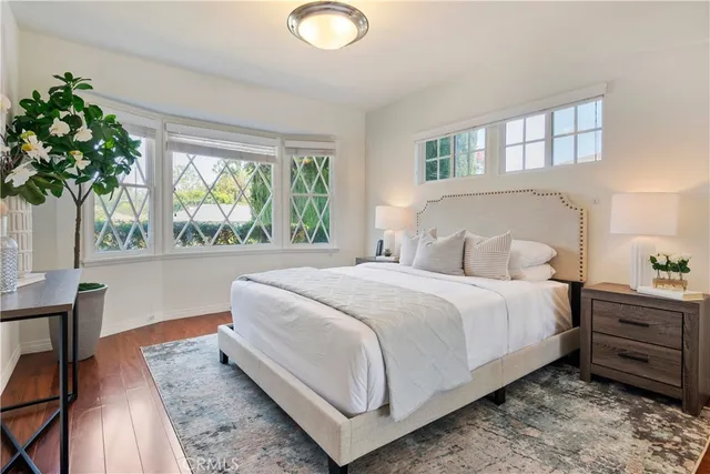 a bedroom with a large bed and a potted plant