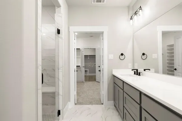 a bathroom with a double vanity sink mirror and shower