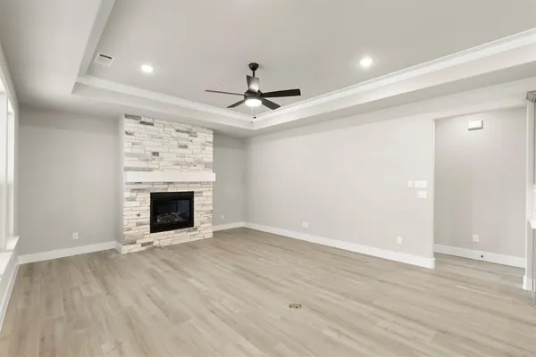 a view of an empty room with a fireplace and a window