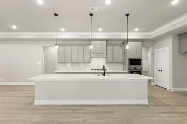 a large white kitchen with stainless steel appliances