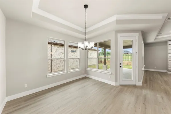 a view of an empty room with glass door and windows