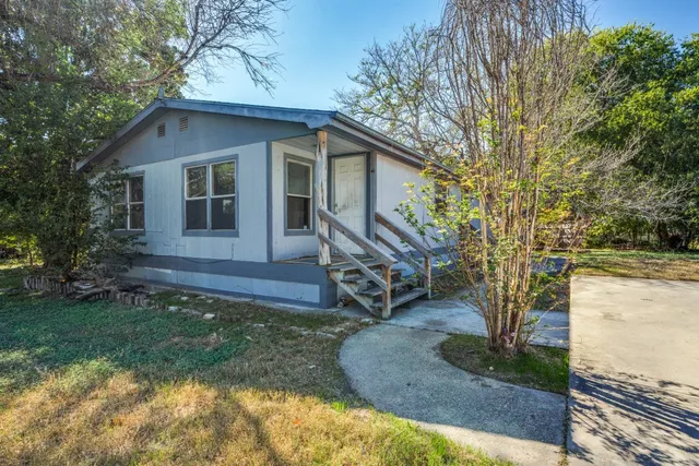 a view of a house with backyard and trees