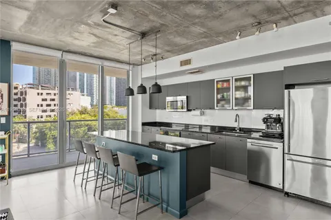 a kitchen with stainless steel appliances granite countertop a stove a refrigerator a kitchen island a sink and a refrigerator