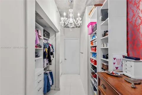a view of walk in closet with clothes and shoes