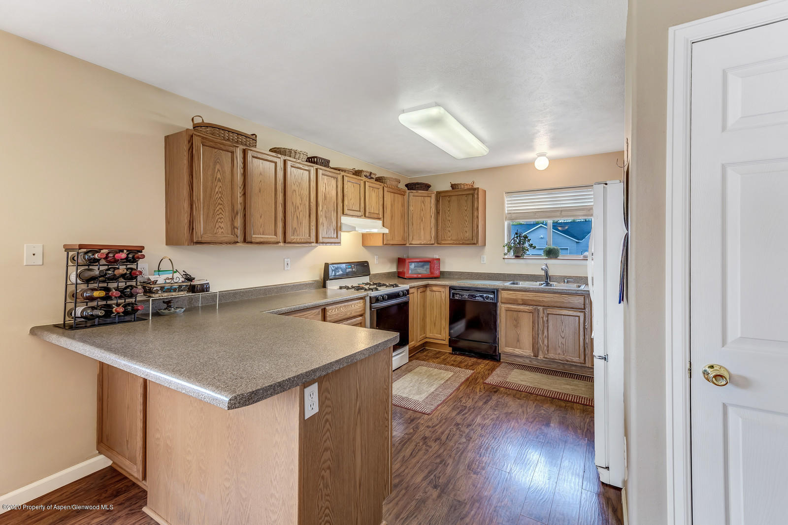1543 Beech Street Rifle, CO 81650 - Photo 7 of 20 a kitchen with a sink a stove a refrigerator and wooden floor