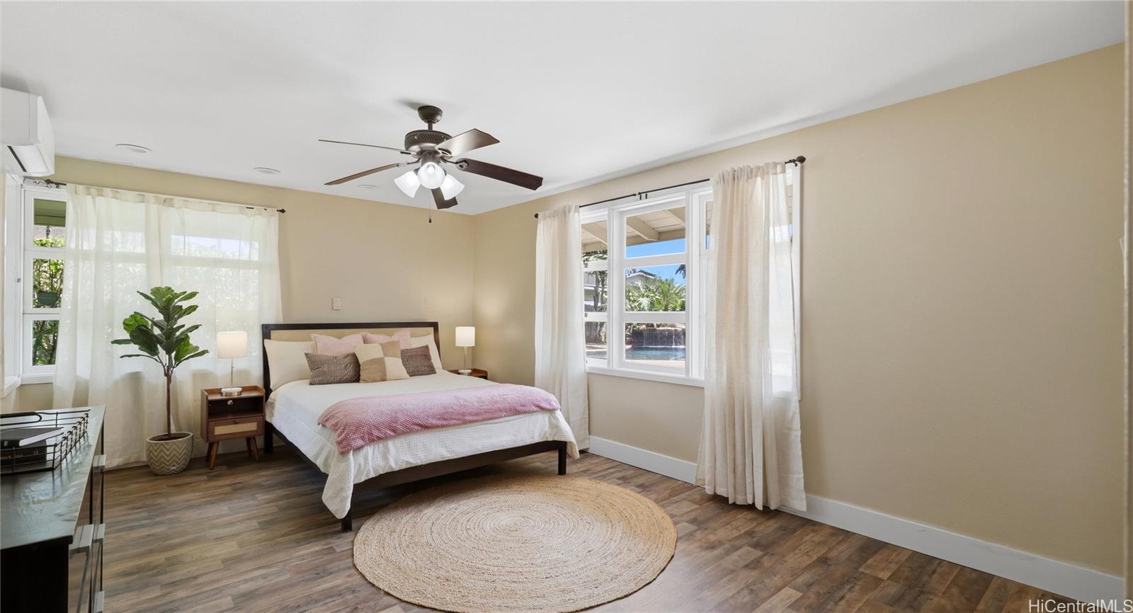 91-779 Fort Weaver Road Ewa Beach, HI 96706 - Photo 16 of 25 Main-level bedroom featuring split AC, a ceiling fan, and large windows overlooking the pool area.