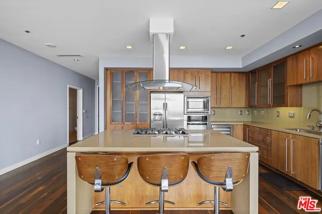 a kitchen with stainless steel appliances granite countertop a dining table chairs sink and cabinets