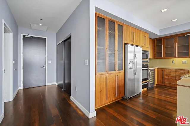 a view of a kitchen with refrigerator and wooden floor